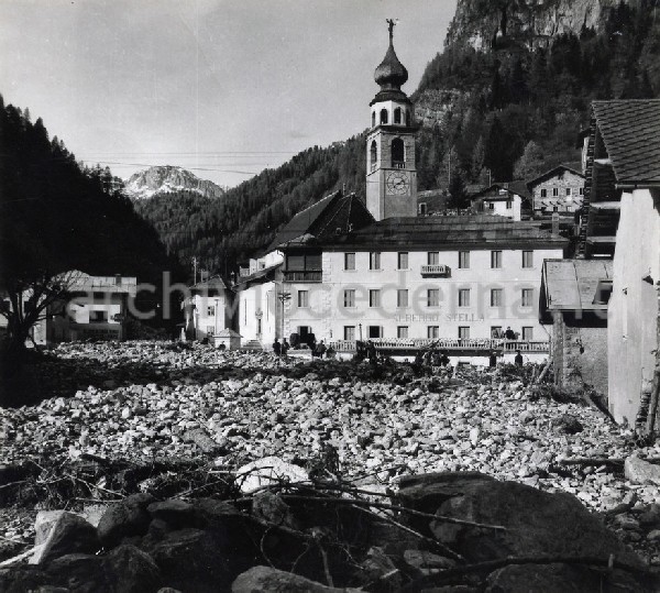 "Provincia di Belluno - la piazza dell'abitato di Cencenighe sommersa dai detriti trasportati dal torrente Biois in piena eccezionale."