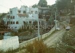 Parco dei Camaldoli (Na): "notare in fondo al viale il cumulo di pietre di tufo che gli operai stanno portando all'interno dell'abitazione abusiva; sulla sinistra della conifera � in azione una betoniera. 2/11/88"